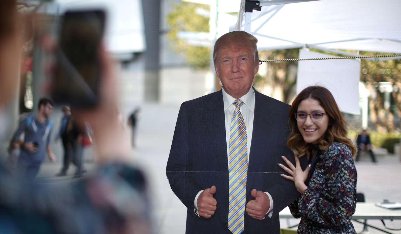 New US citizen Elena Rosales, 18, who emigrated from Mexico, poses with a cardboard cutout of US President Donald Trump after a naturalisation ceremony in Los Angeles last week. Photo: Reuters