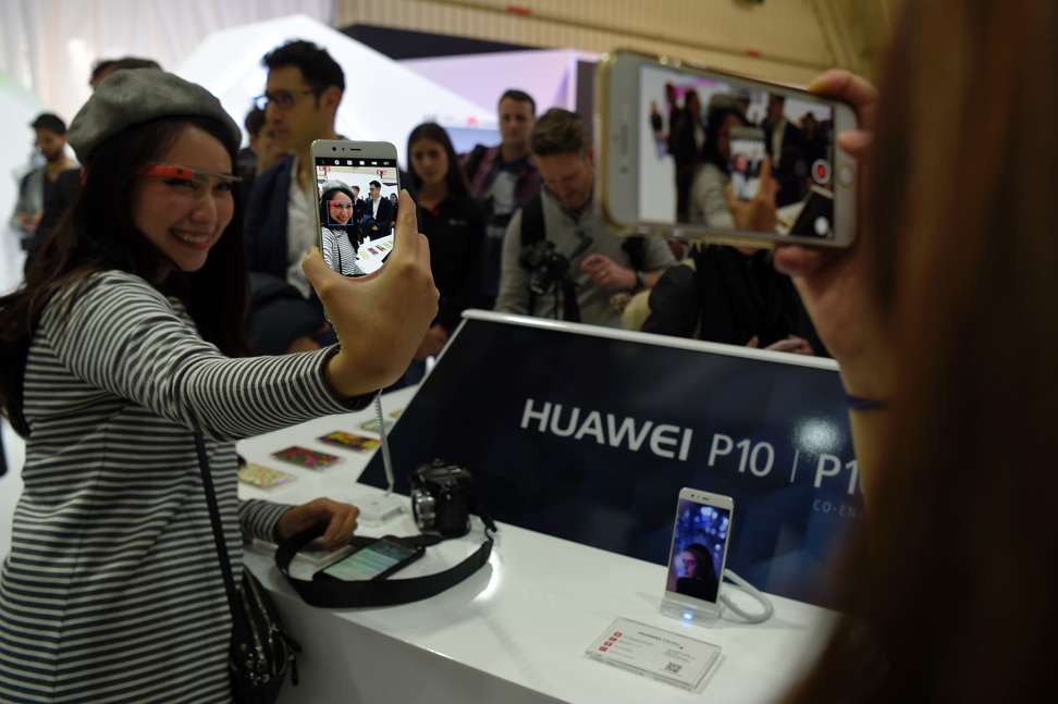 Journalists check the new Huawei P10 at the official launch. Photo: AFP