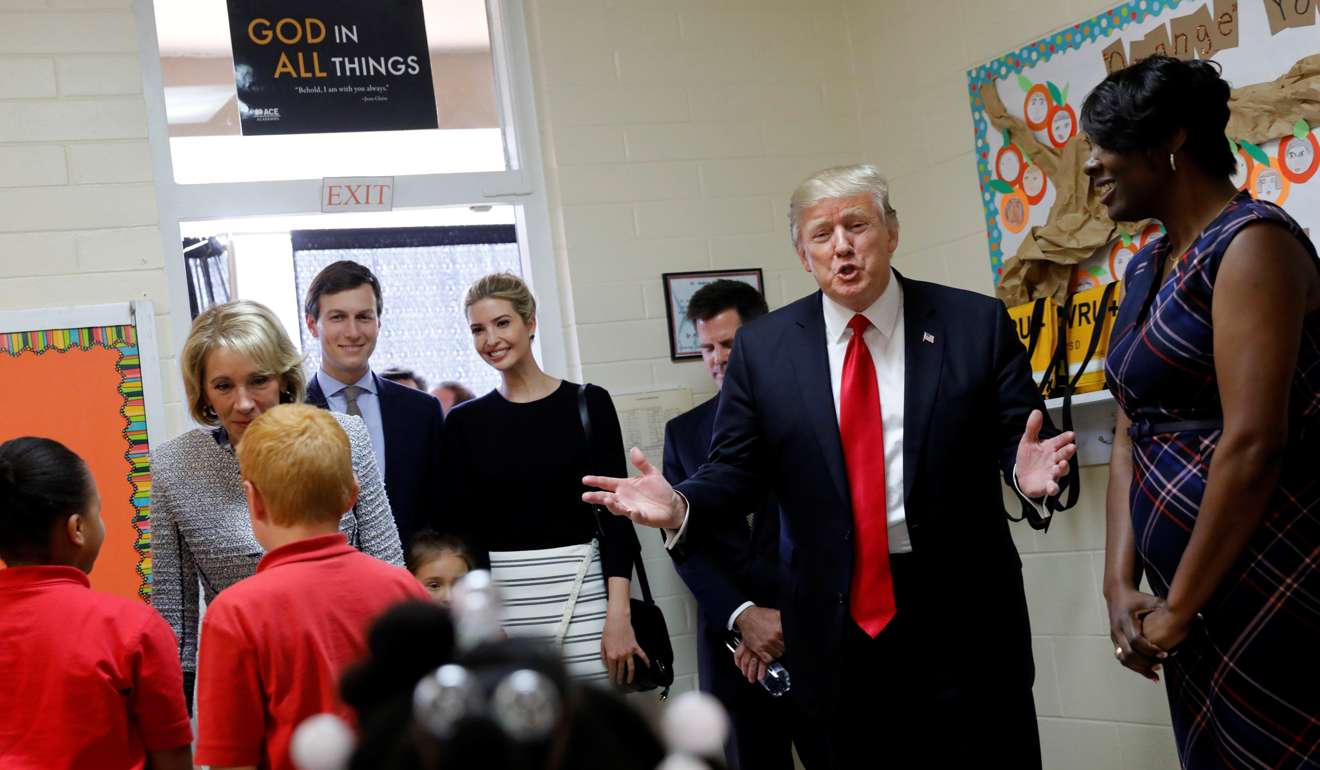 US President Donald Trump (2nd R), joined by Education Secretary Betsy DeVos (from L), Senior advisor Jared Kushner, daughter Ivanka Trump and Saint Andrew Catholic School Principal Latrina Peters-Gipson (R), visits a classroom at the school in Orlando, Florida. Photo: Reuters