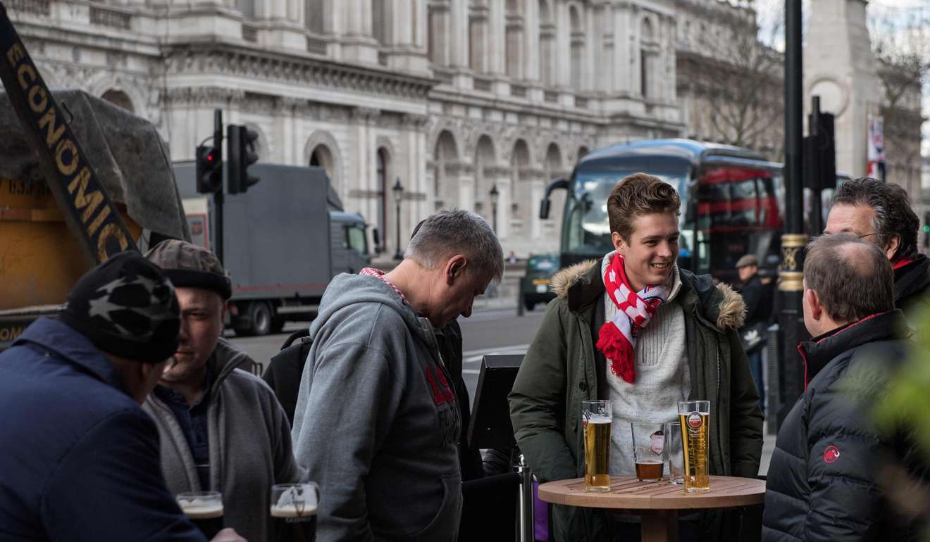 A group of men talk with their pints of beer and lager drinks outside a pub in central in London. Britain's Finance minister Philip Hammond earlier this week said he would keep chopping away at the deficit to get Britain fit to face Brexit. Photo: AFP