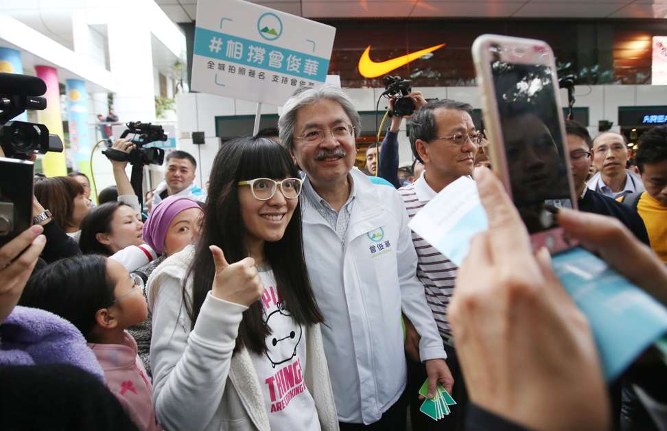 Chief executive candidate John Tsang Chun-wah, the popular underdog in the race, poses with supporters. Photo: Edward Wong