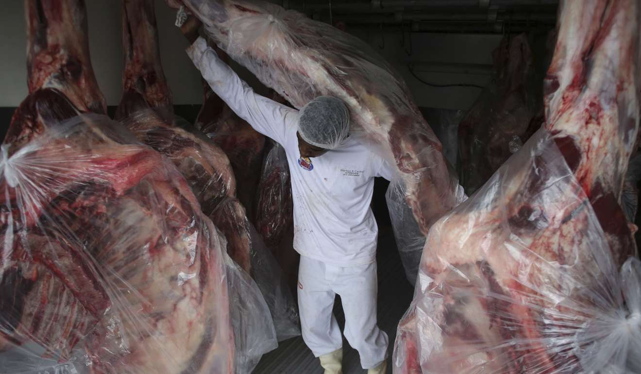 A man delivering sides of beef to a butcher shop in Brasilia, Brasil, on Monday. Photo: AP