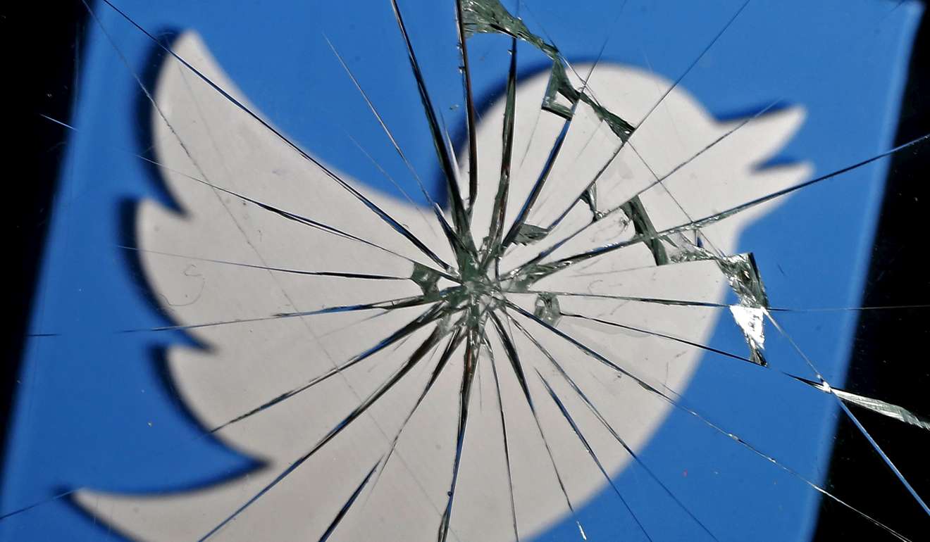 The logo of Twitter seen through broken glass. Photo: Reuters