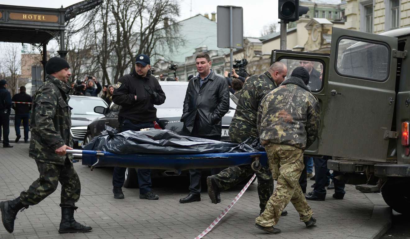 The slain body of Denis Voronenkov is carried away by forensic experts in downtown Kiev. Photo: EPA