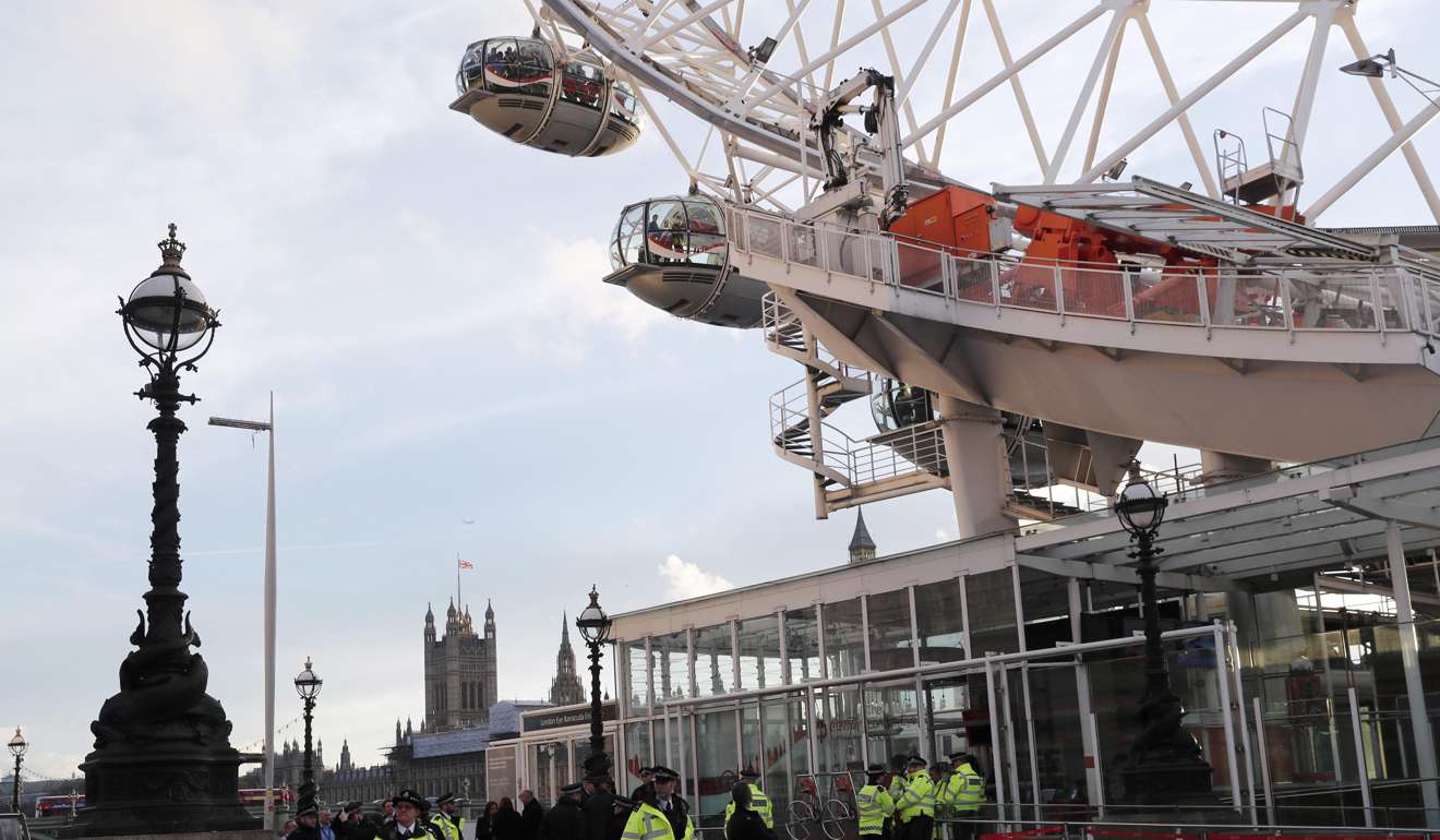 Police officers stand at the exit as people are seen inside the pods on the London Eye after it was stopped following an attack on Westminster Bridge in London. Photo: Reuters
