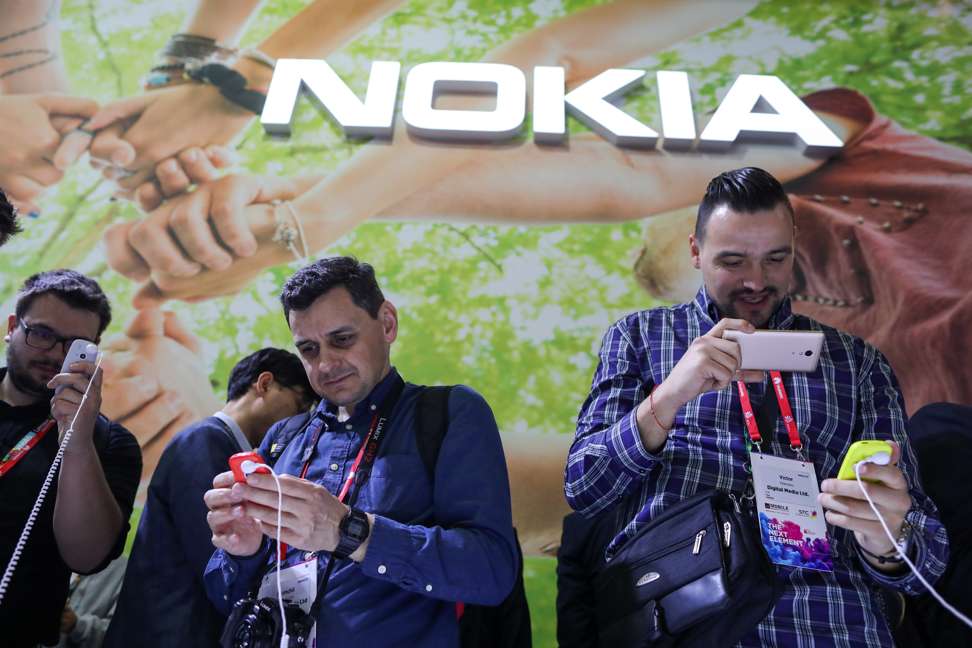 Attendees try Nokia 3310 mobile phones, manufactured by HMD Global, on the opening day of the Mobile World Congress. Photo: Bloomberg