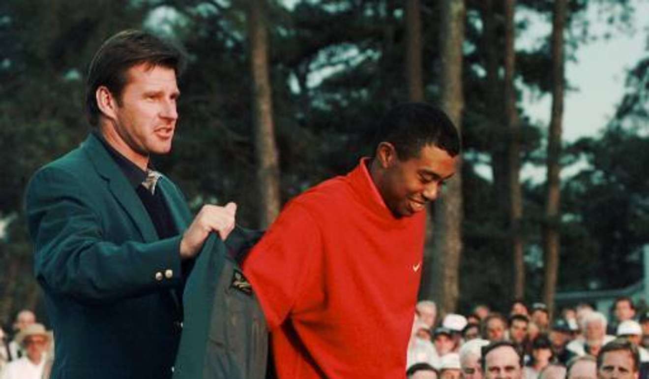 Nick Faldo helps Tiger Woods pull on his first Green jacket 20 years ago. Photo: AP