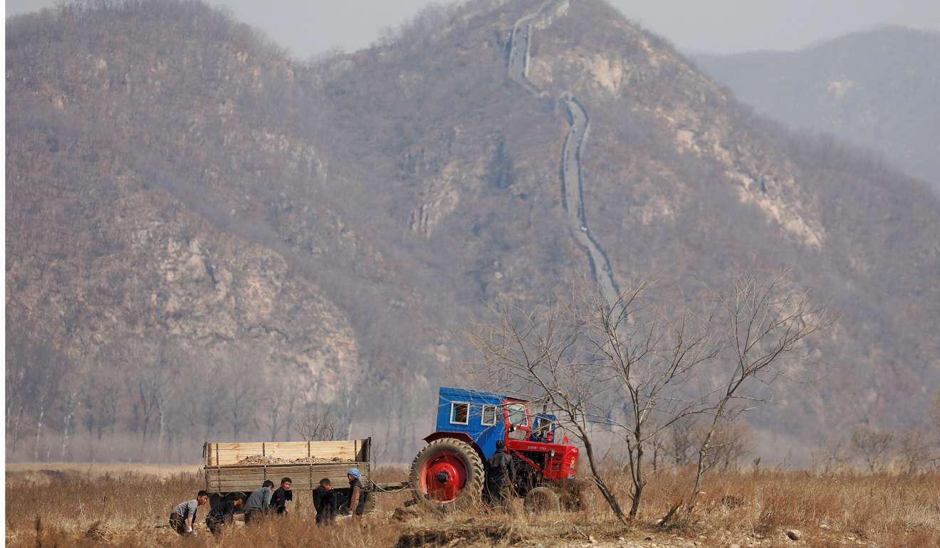 North Korean farmers work in a field north of the town of Sinuiju. A section of the Great Wall can be seen on the Chinese side of the Yalu River. The way forward diplomatically necessitates an understanding of China’s attitude and behaviour regarding the North. Photo: Reuters