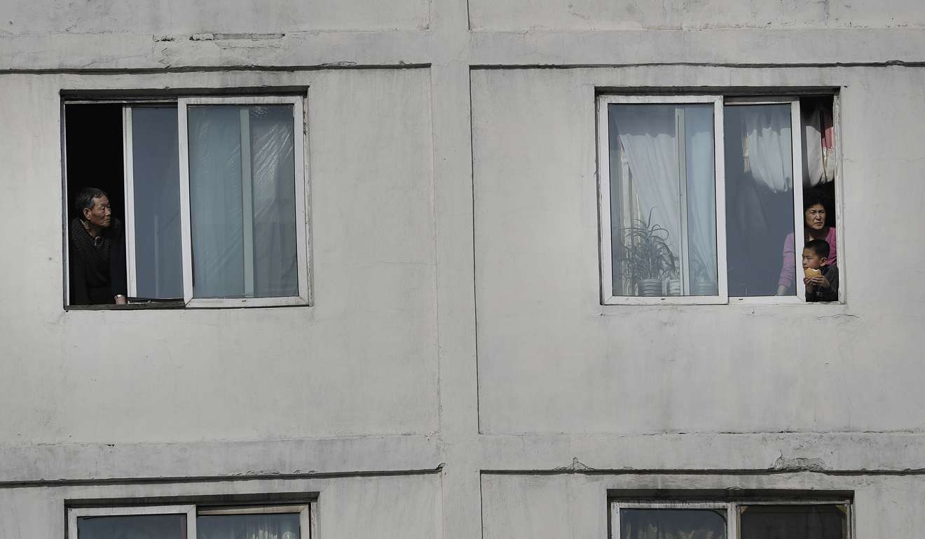 North Koreans watch runners of the Pyongyang marathon from their apartment windows. Photo: AP