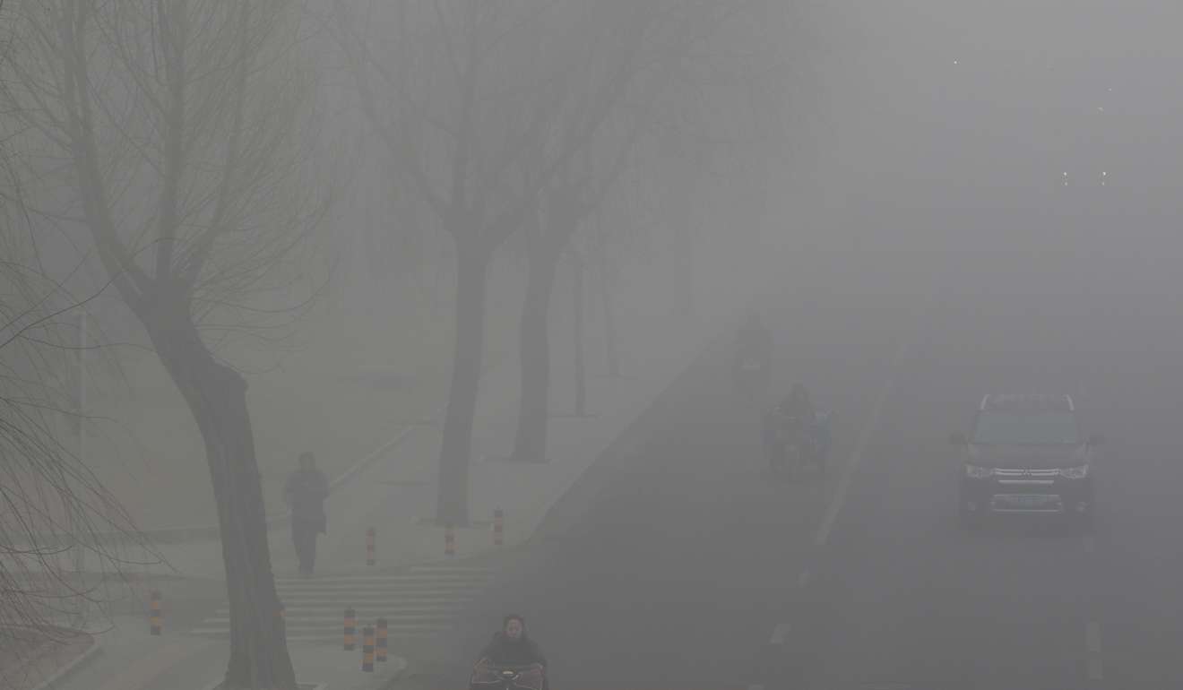 People drive and ride amid smog in Beijing in February. Photo: Reuters