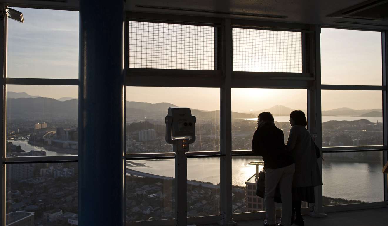 Visitors look out from an observation deck in Fukuoka, Japan.  Photo: Bloomberg