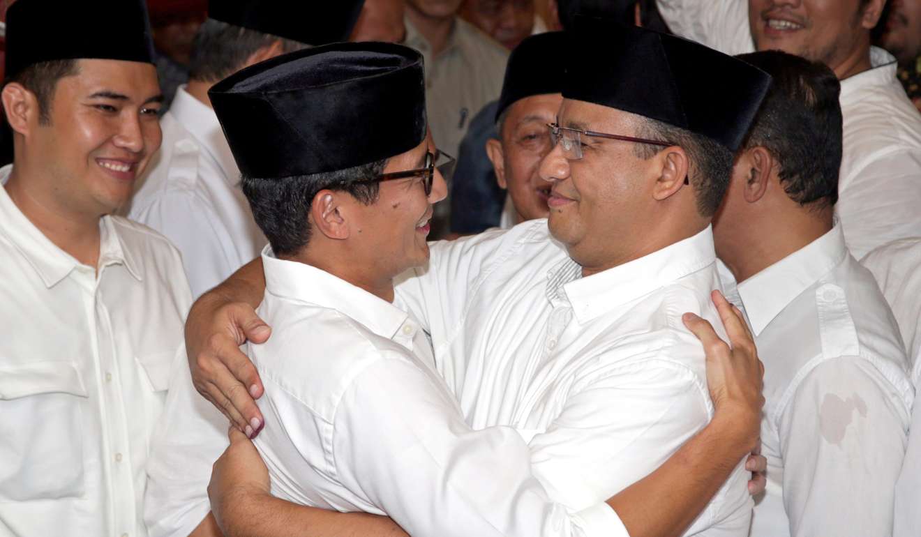 Anies Baswedan (right) hugs his running mate Sandiaga Uno after exit polls in Jakarta. Photo: EPA