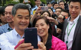 A visitor poses with Chief Executive Leung Chun-ying for a picture during the Government House annual open day in Central. Photo: Felix Wong