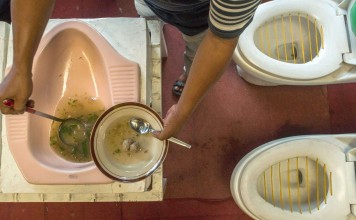 Customers being served meatball soup from a squat toilet at Jamban Cafe in Semarang, Indonesia. Photo: AFP