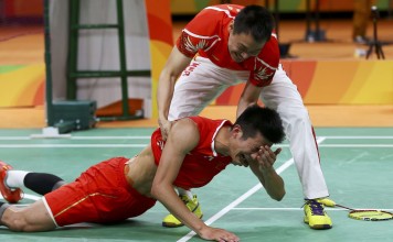 China’s Chen Long is helped up by a coach as he celebrates after winning his gold-medal match against Lee Chong Wei of Malaysia. Photo: Reuters