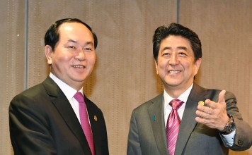 Japanese Prime Minister Shinzo Abe and Vietnamese President Tran Dai Quang shake hands in Lima. Photo: Kyodo