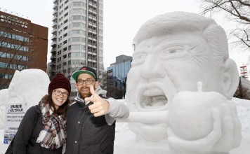 Tourists pose for photos in front of a snow statue of US President Donald Trump in Sapporo. Photo: Kyodo