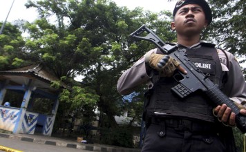 A policeman holds a rifle at a location where a suspected supporter of Islamic State attacked policemen in Tangerang, Indonesia's Banten province. Photo: Reuters.