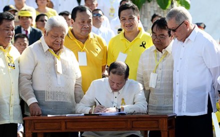 Philippine President Benigno Aquino (centre) signs the Martial Law Compensation bill during the 27th anniversary of the People Power revolution at the People Power monument in Manila on Monday. Photo: AFP Philippine President Benigno Aquino (centre) signs the Martial Law Compensation bill during the 27th anniversary of the People Power revolution at the People Power monument in Manila on Monday. Photo: AFP