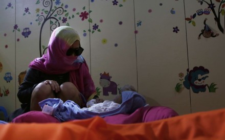 Harra Kazuo with her newborn boy. Harra’s husband, Jaypee Bertes, was killed along with his father, Renato Bertes, in police custody before the child’s birth. Photo: Thomas Yau