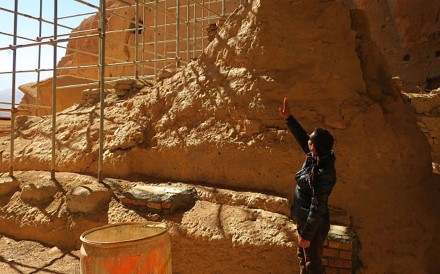 Afghan archaeological guard Hakim Safam in front of the reconstructed foot of the Salsal Buddha. Photo: AFP