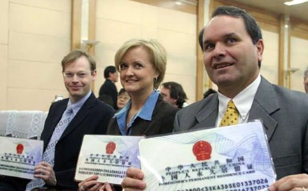 A file picture of foreigners holding larger, display copies of the old permanent residency cards. Photo: Handout