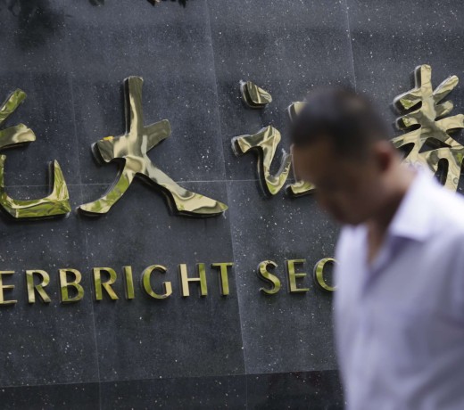 A man walks past the sign of Everbright Securities Ltd. in Shanghai, Phot AP, Eugene Hoshiko)