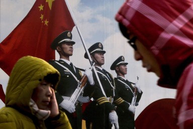 People walk past a poster of Chinese People's Liberation Army soldiers in Beijing. Photo: AP People walk past a poster of Chinese People's Liberation Army soldiers in Beijing. Photo: AP