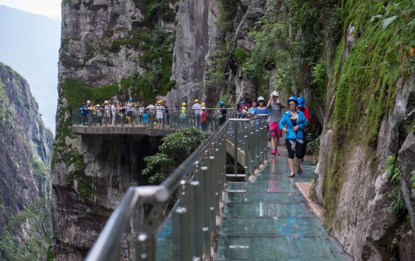 Tourists walk on a glass skywalk in Shimenguan scenic spot in Dali, southwest China's Yunnan Province. Photo: Xinhua