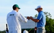 Jordan Spieth and his caddy bump fists after holing out on 18. Photo: AFP