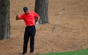 Tiger Woods flinches after hitting a tree root under the pine straw on the ninth hole during the final round of the Masters. "A bone kind of popped out and the joint kind of went out of place, but I put it back in," Woods said. Photo: AFP