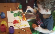 Leon, 18 months old, paints at home. We Play At Home maps out theme- and project-based activities for each child.