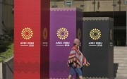 A man dressed in traditional Andean clothes walks past the logo of the APEC 2016 summit in Lima, Peru. Photo: AP