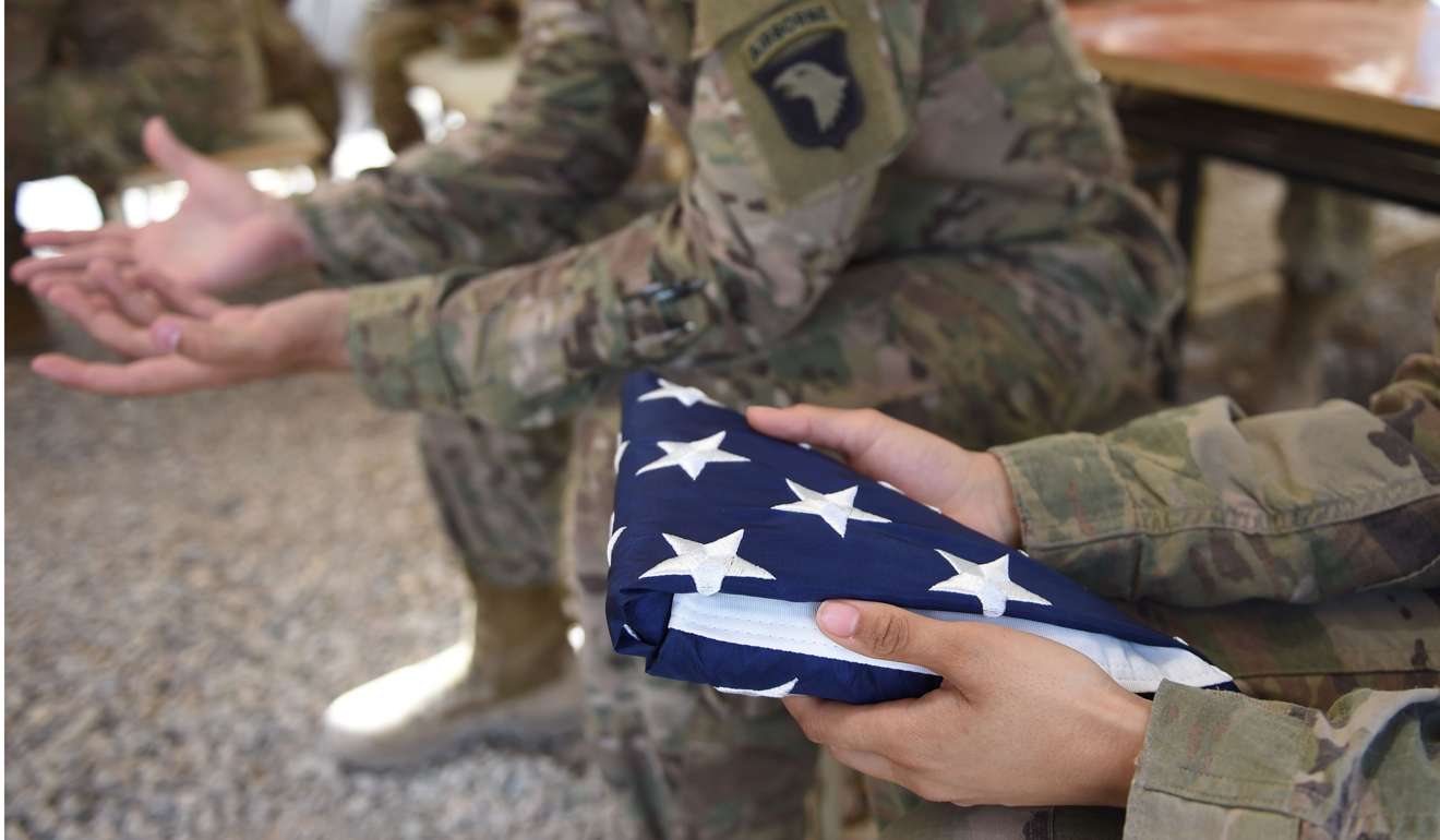 A US soldier holds the national flag ahead of a handover ceremony at Leatherneck Camp in Lashkar Gah in the Afghan province of Helmand on Saturday. The US has almost 40 “named bases” around the world, military deployments in more than 150 countries, and over 300,000 of its personnel abroad. Photo: AFP