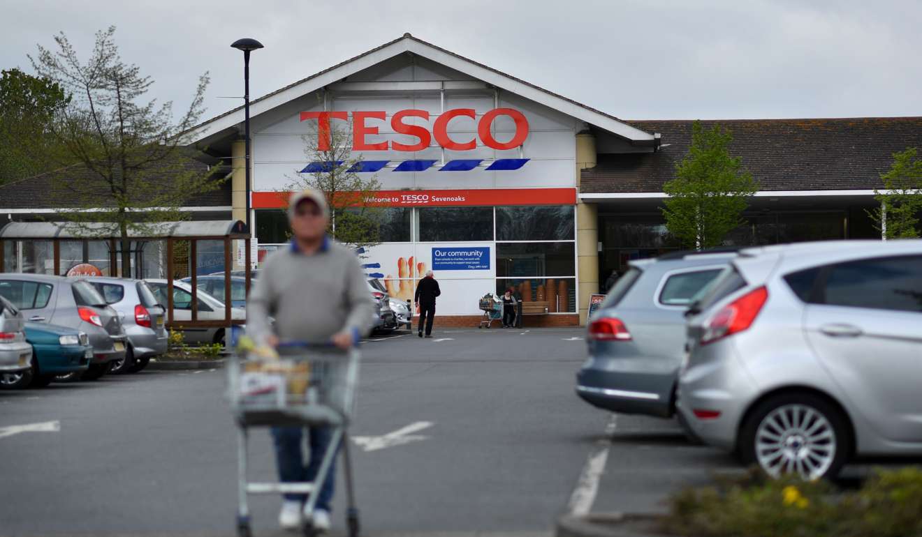 A customer pushes a shopping trolley as he walks through the car park of a Tesco store in Sevenoaks, south-east of London. Photo: AFP