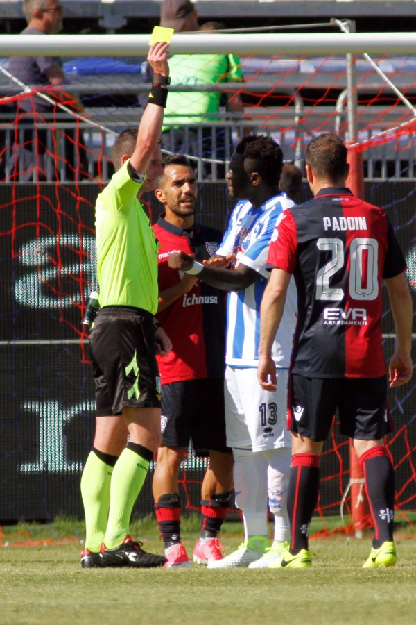 Referee Daniele Minelli books Pescara’s Muntari as the player protests. Photo: AP
