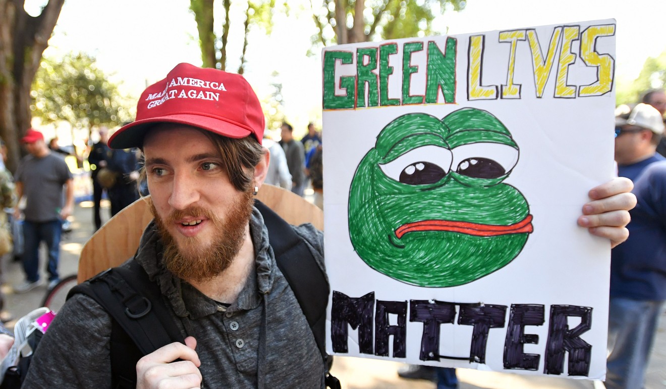 Andrew Knight holds a sign of Pepe the frog, an alt-right conservative icon, during a rally in Berkeley, California on April 27. Photo: AFP