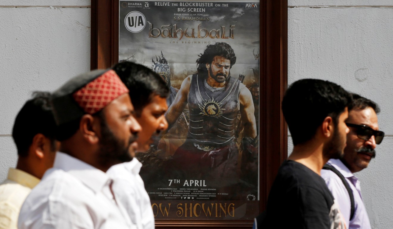 People walk past a poster advertising Baahubali: The Beginning outside a cinema in New Delhi last month. Its sequel has become the biggest grossing Indian film. Photo: Reuters