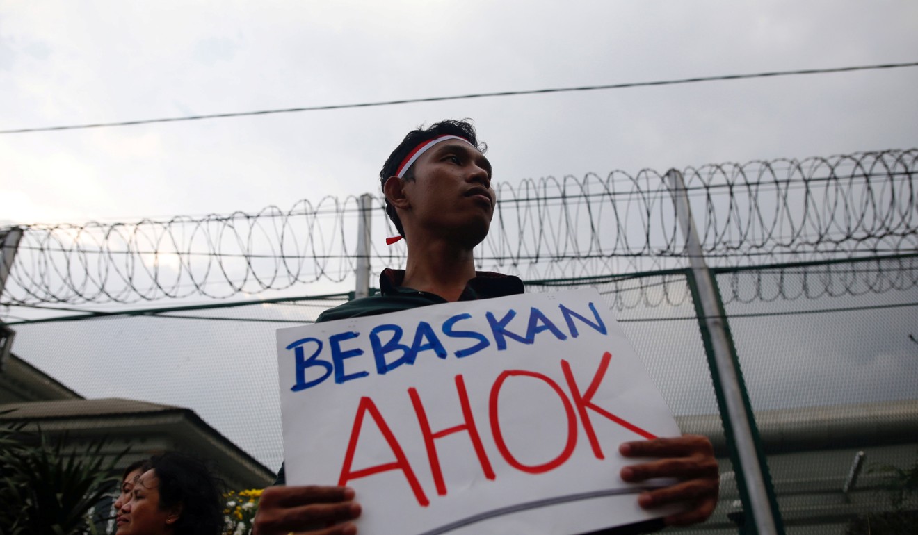 A man holds a sign which says ‘Free Ahok’ during a protest by supporters of Jakarta Governor Basuki Tjahaja Purnama. Photo: Reuters