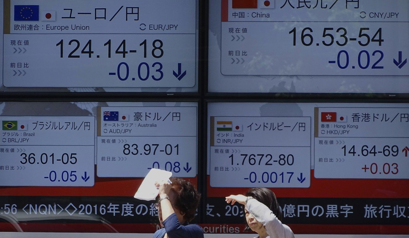 Women stand in front of an electronic stock board showing foreign currency exchange rates at a securities firm in Tokyo . The dollar slid on fears US President Donald Trump could face impeachment charges. Photo: AP
