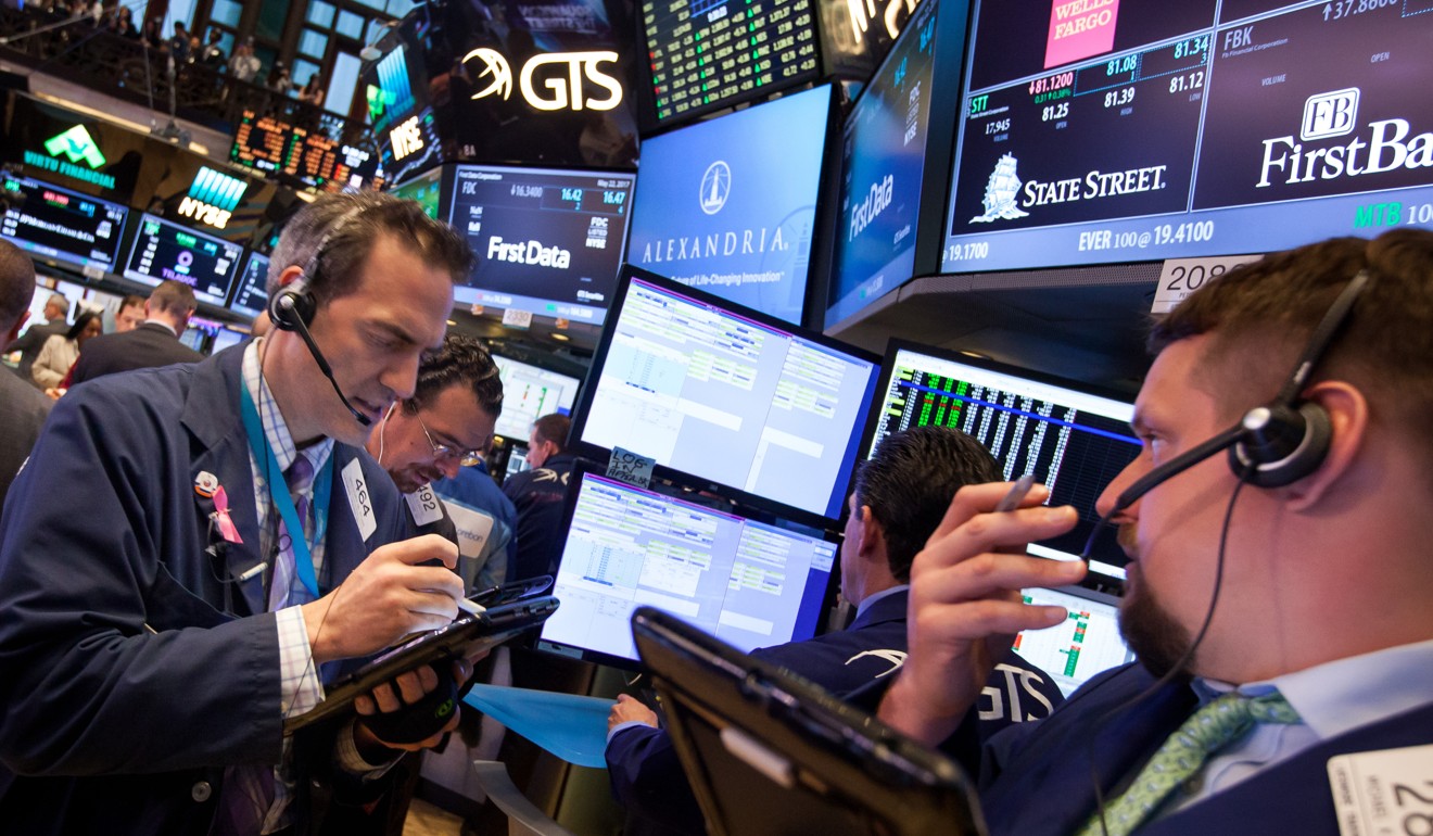 Traders fill their orders in the New York Stock Exchange (NYSE) as stocks edged up after the Fed minutes tshowed a gradual approach to interest rate increases in 2017. Photo: Bloomberg