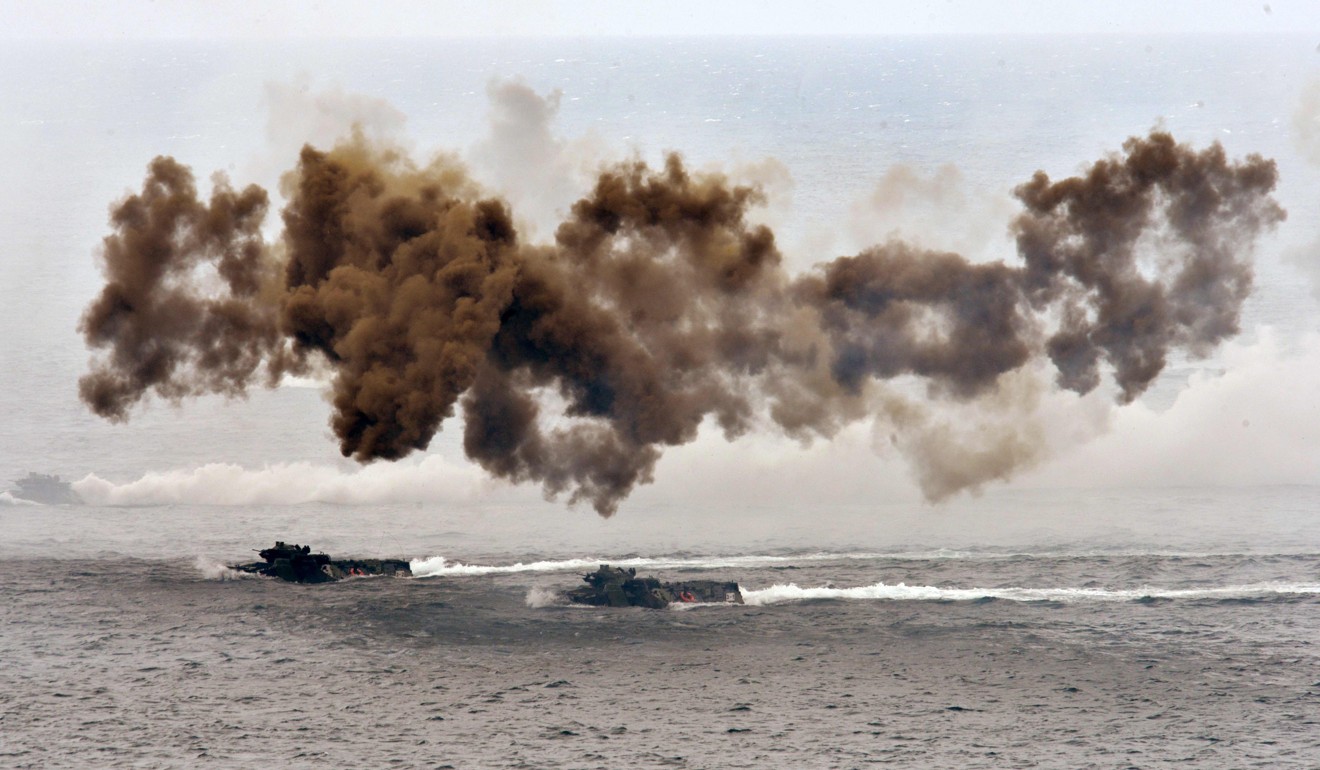 Amphibious assault vehicles release smoke during the drills. Photo: AFP