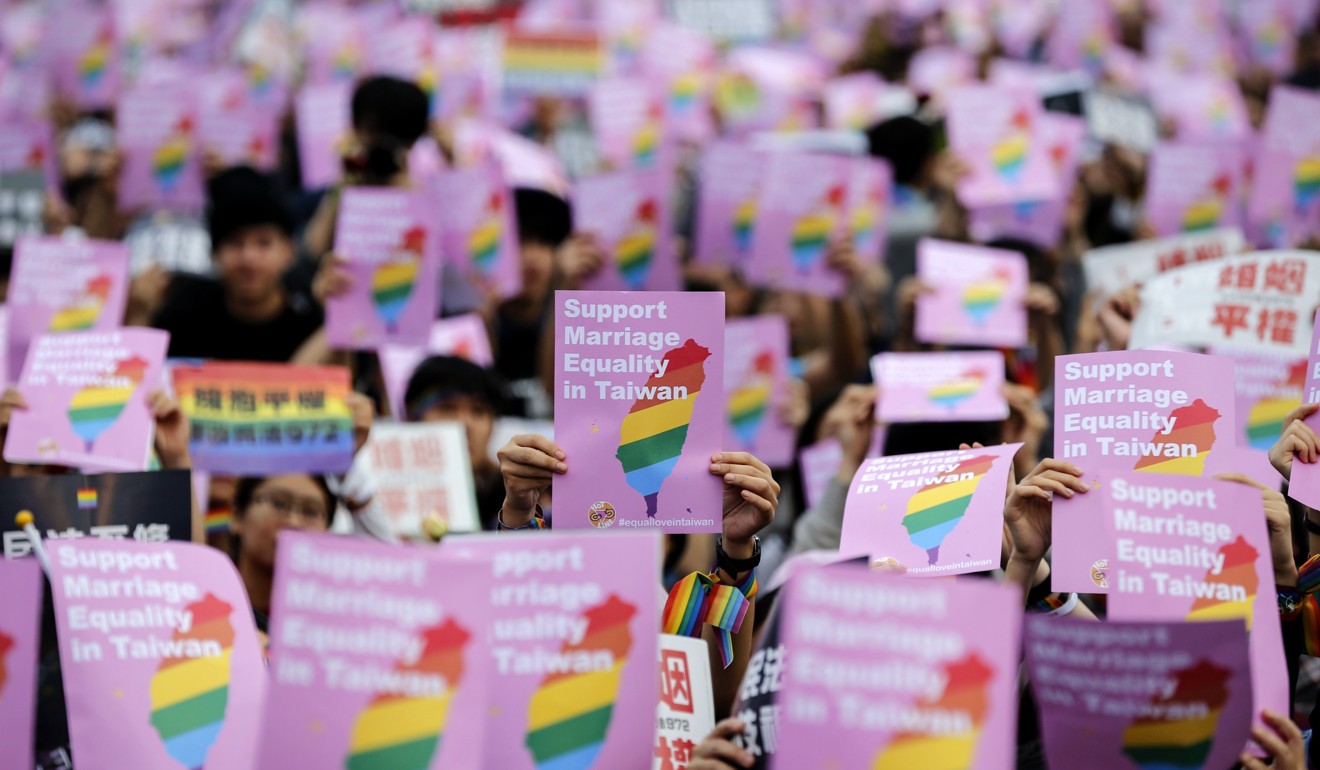 Thousands of supporters of the LGBT community hold banners as they gather to support same-sex marriage at a major street in Taipei. Photo: EPA