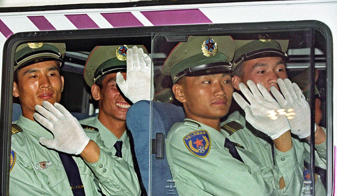 Soldiers from the first batch of the Hong Kong garrison of the PLA wave as they enter a border post from Shenzhen in the closing hours of June 30, 1997, ahead of the handover ceremony. Photo: AFP