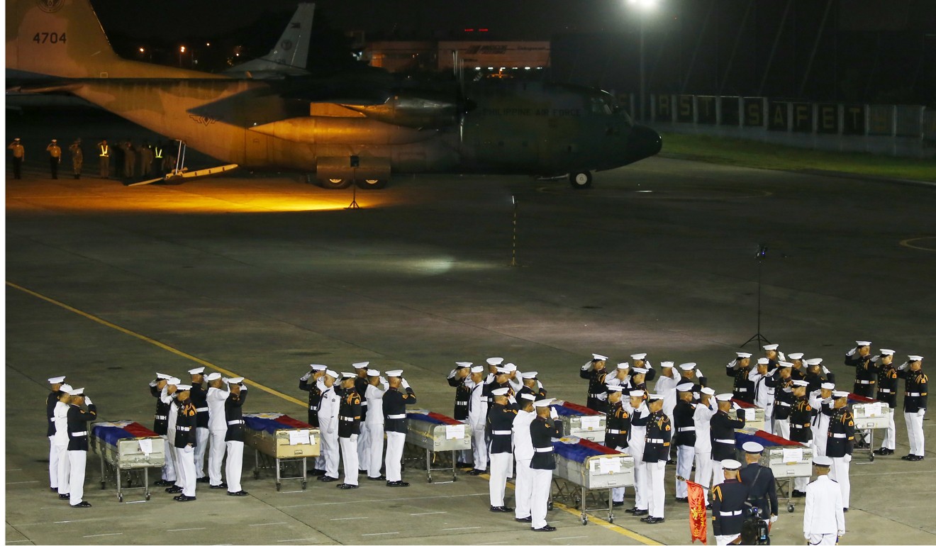 Philippine marines salute the flag-draped caskets of eight of 13 marines killed on Friday. Photo: AP
