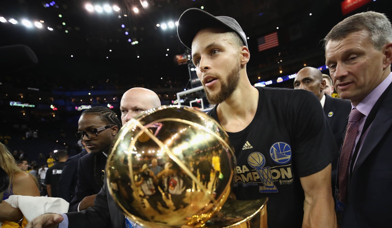 Stephen Curry carries off the Larry O'Brien Championship trophy. Photo: AFP