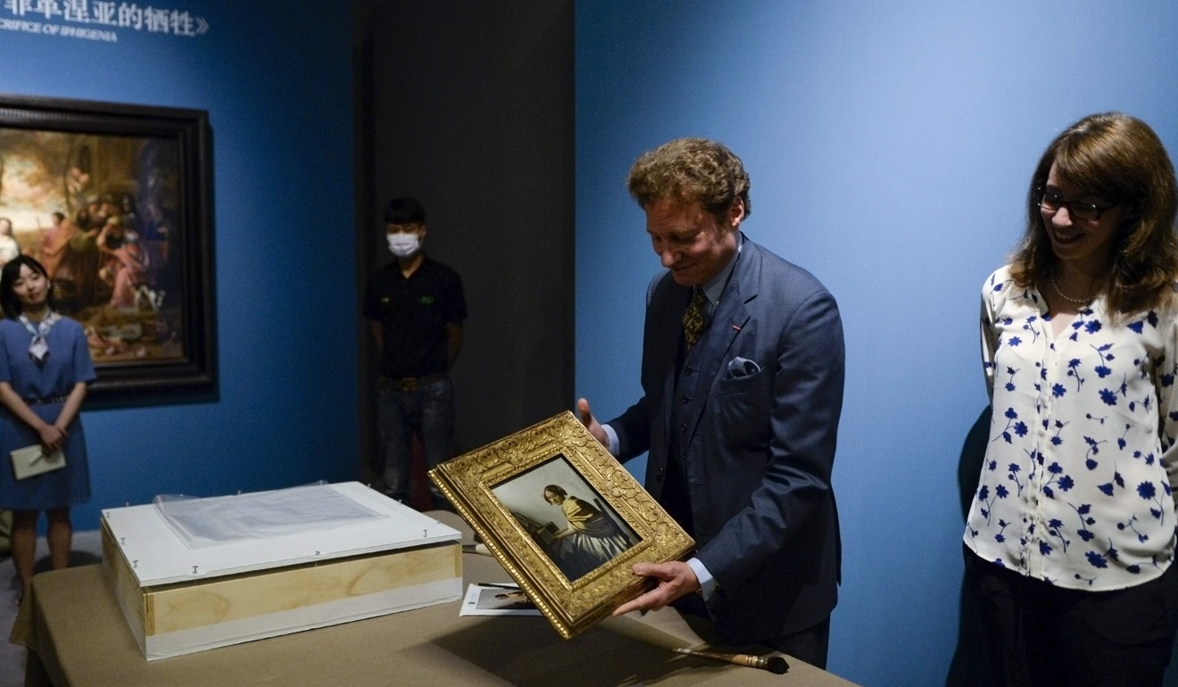 US art collector Tom Kaplan shows Vermeer's ‘Young Woman Seated at a Virginal’, on display as part of the Masterpieces from The Leiden Collection exhibition at the National Museum in Beijing. Photo: AFP