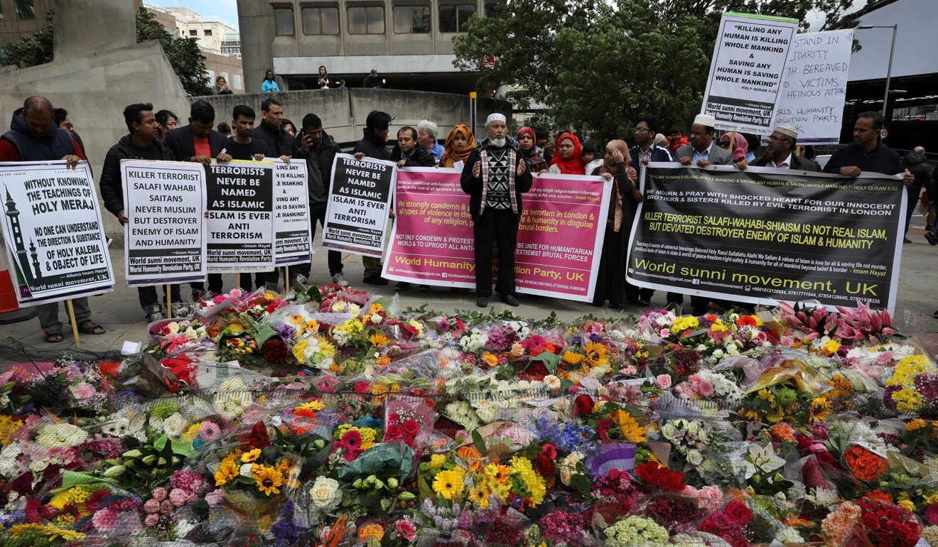 Muslims hold placards near floral tributes for the victims of the attack on London Bridge and Borough Market. File photo: Reuters