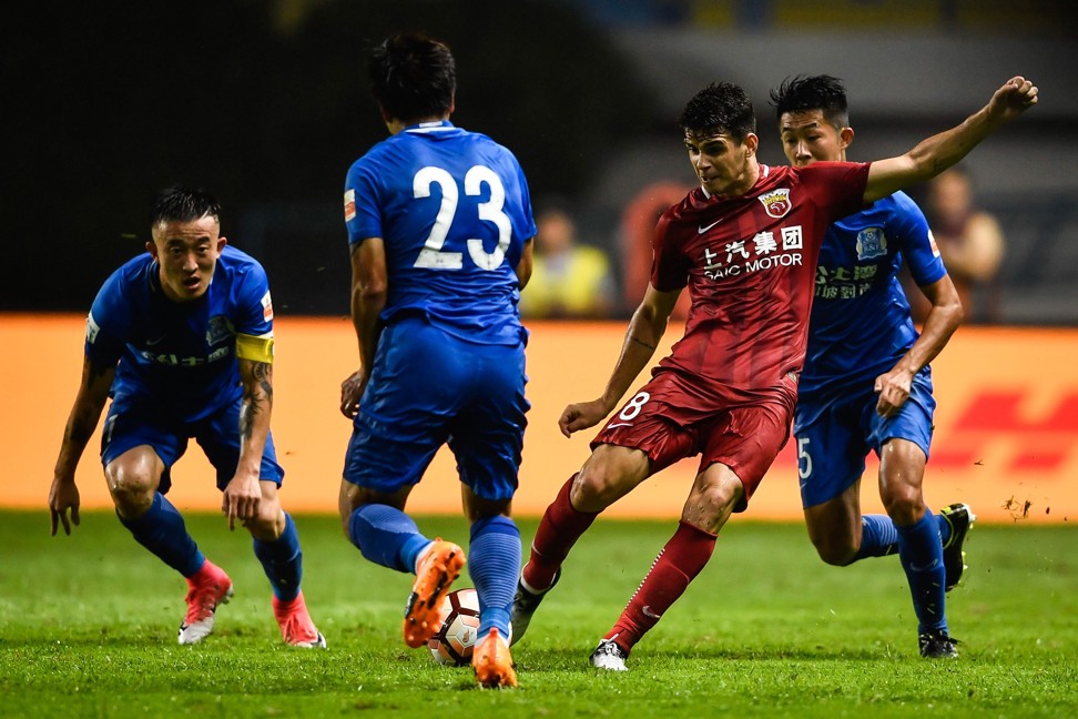 Shanghai SIPG's Oscar kicking the ball at a Guangzhou R&F player. Photo: AFP