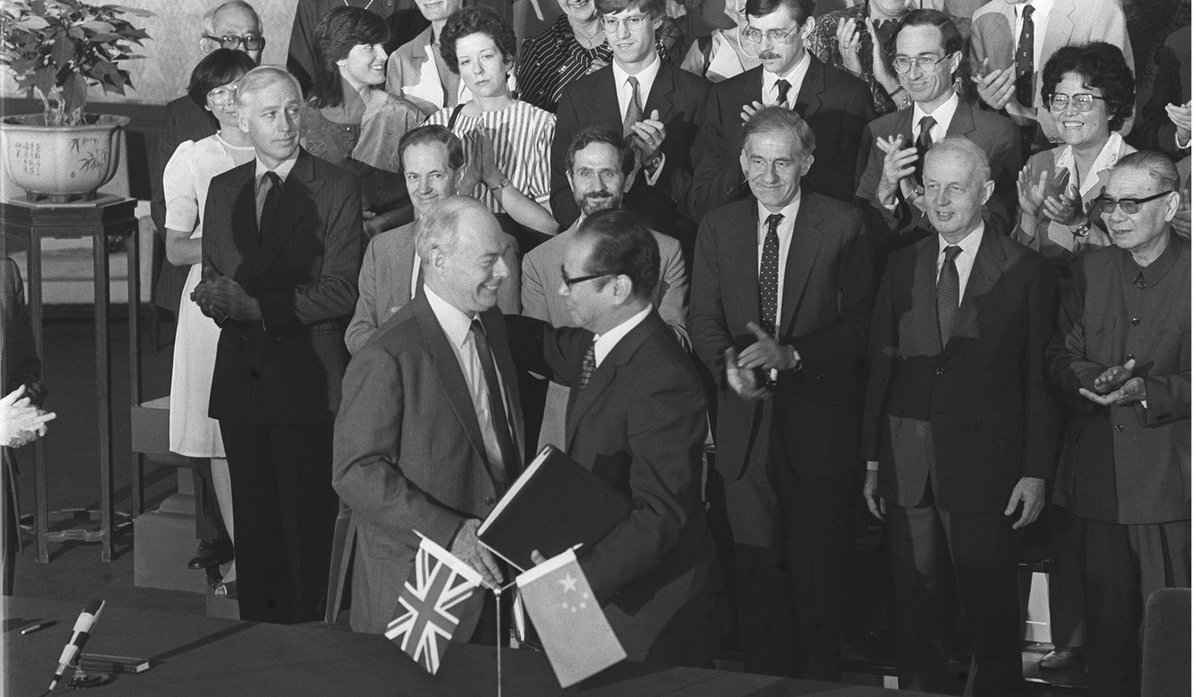 Sir Richard Evans (left), the British ambassador to China, and Zhou Nan, chairman of the Chinese negotiating team, exchange documents after putting their signatures to the Joint Declaration on Hong Kong’s future, while members of the two negotiating teams look on, in September 1984. Photo: P. Y. Tang